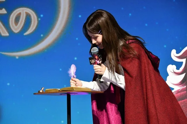 Mei Hata onstage speaking to press