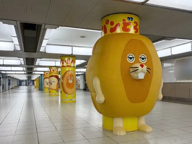 Commuters passing the Pan-dorobō station display